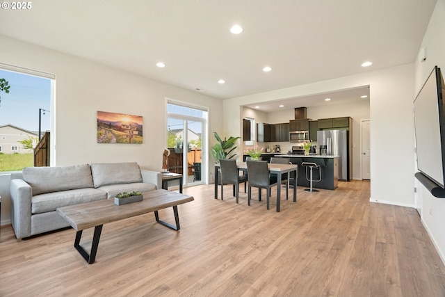 living room featuring light wood-type flooring, recessed lighting, and baseboards