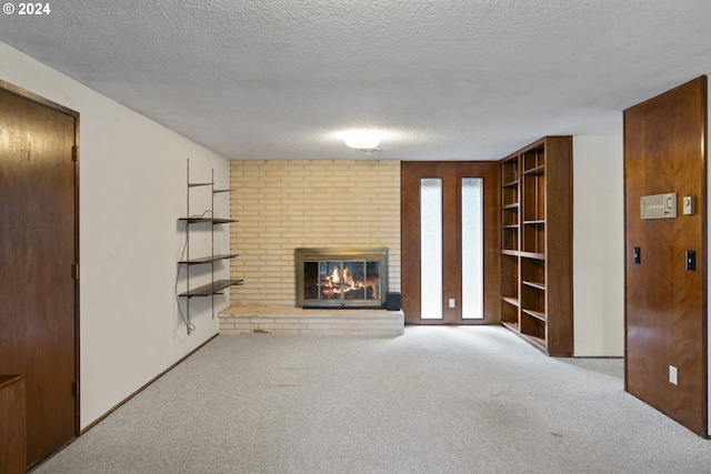 unfurnished living room with a textured ceiling, a fireplace, and light colored carpet