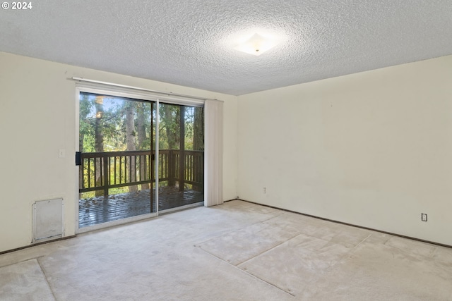 carpeted spare room featuring a textured ceiling