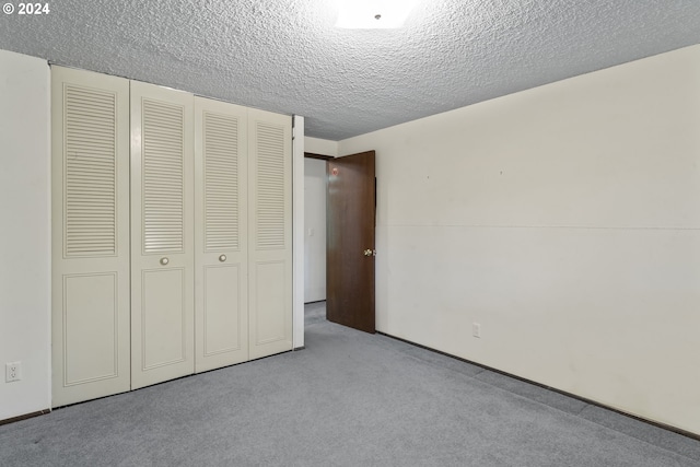 unfurnished bedroom with a textured ceiling and light colored carpet