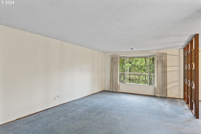 carpeted empty room with a textured ceiling