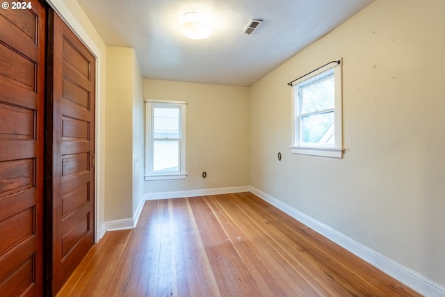 empty room featuring a healthy amount of sunlight and light hardwood / wood-style flooring