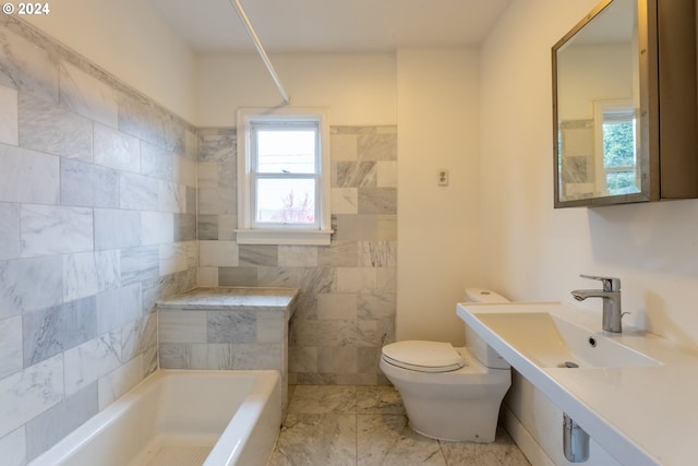 bathroom featuring toilet, a tub to relax in, tile walls, and sink