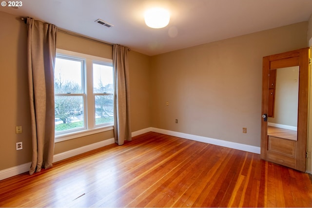 unfurnished room with hardwood / wood-style flooring