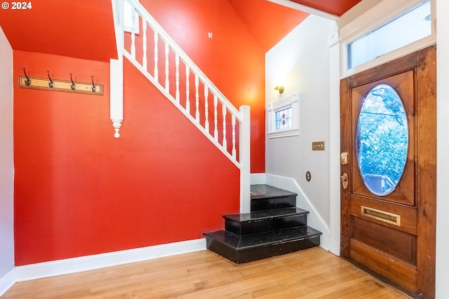 foyer entrance featuring lofted ceiling and hardwood / wood-style flooring