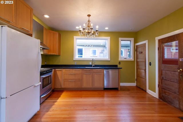 kitchen featuring sink, a notable chandelier, light hardwood / wood-style floors, and stainless steel appliances