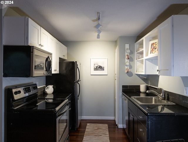 kitchen with sink, rail lighting, stainless steel appliances, dark hardwood / wood-style flooring, and white cabinets