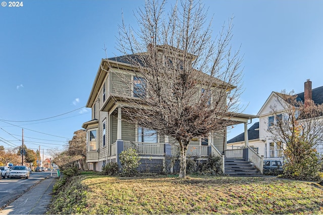 view of front of property featuring covered porch and a front yard