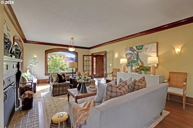 living room with ornamental molding, hardwood / wood-style floors, a textured ceiling, and a fireplace