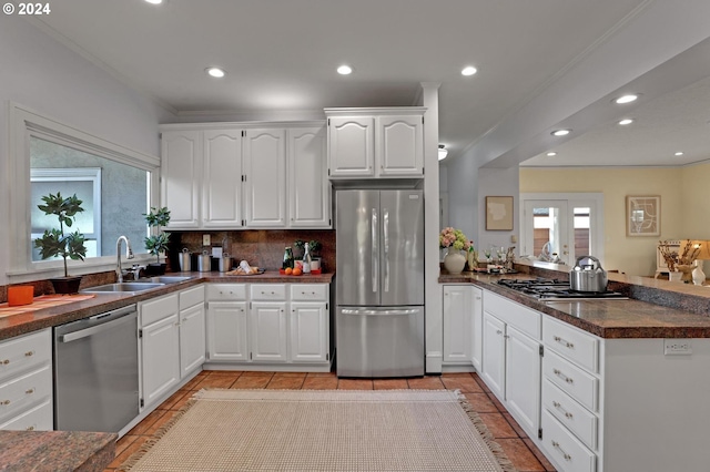 kitchen featuring sink, white cabinets, stainless steel appliances, and tasteful backsplash