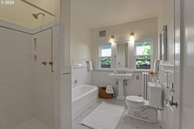 bathroom with toilet, tile patterned floors, tile walls, and plus walk in shower