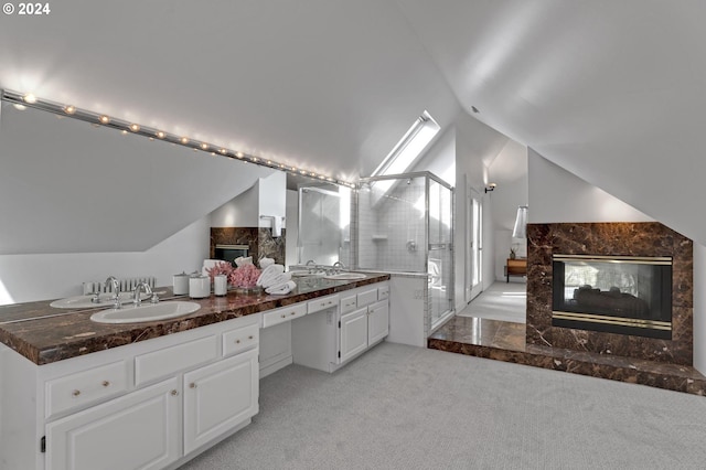 bathroom with vanity, lofted ceiling with skylight, a high end fireplace, and walk in shower