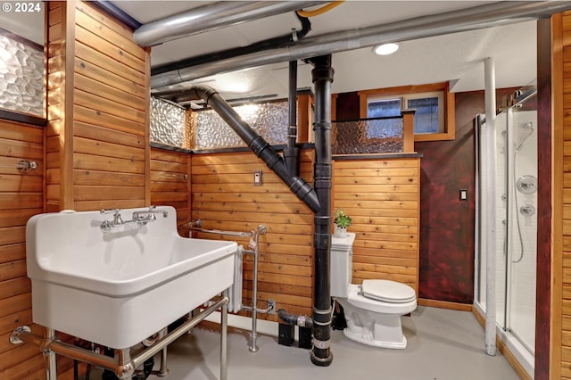 bathroom with toilet, concrete floors, wood walls, and walk in shower