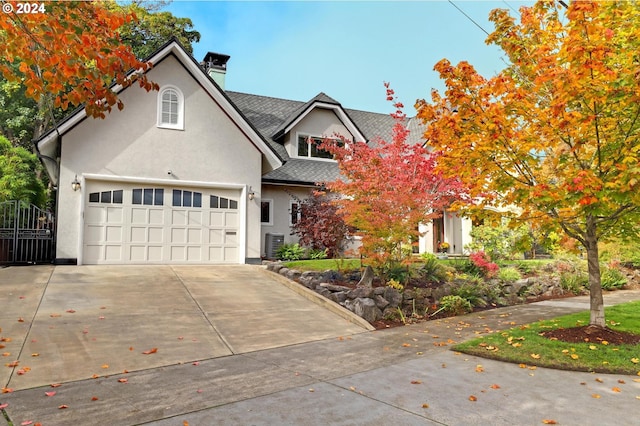 view of front of home with central air condition unit and a garage