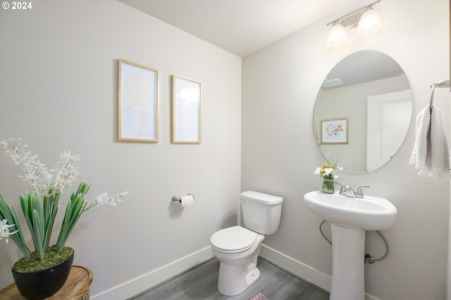 bathroom featuring hardwood / wood-style flooring, toilet, and sink