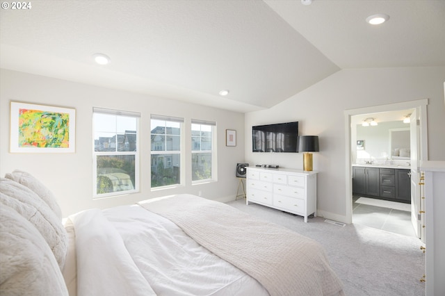 bedroom featuring connected bathroom, vaulted ceiling, and light colored carpet