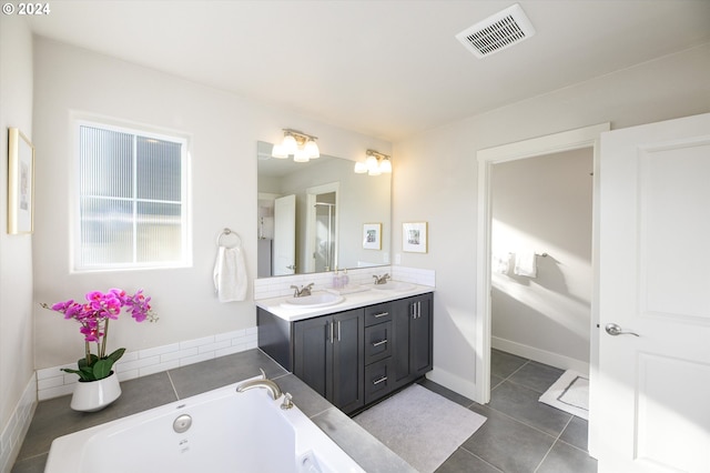 bathroom with vanity, a bathing tub, and tile patterned floors