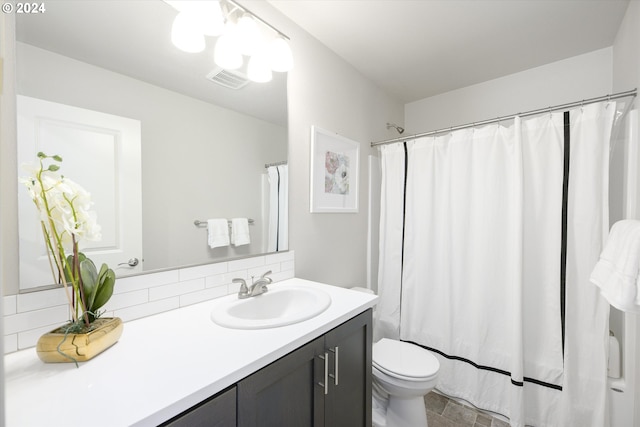 bathroom with vanity, walk in shower, decorative backsplash, and toilet