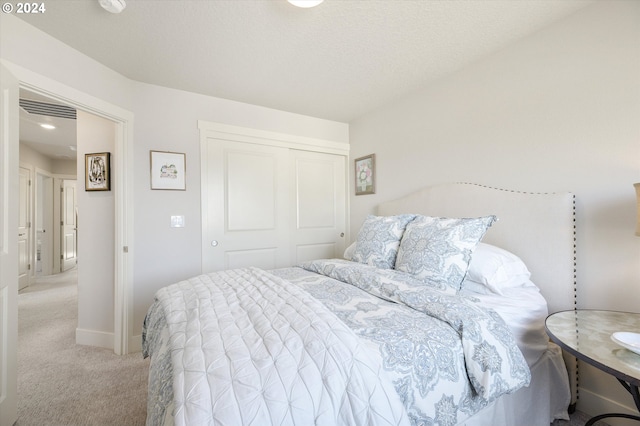 bedroom with light colored carpet and a closet