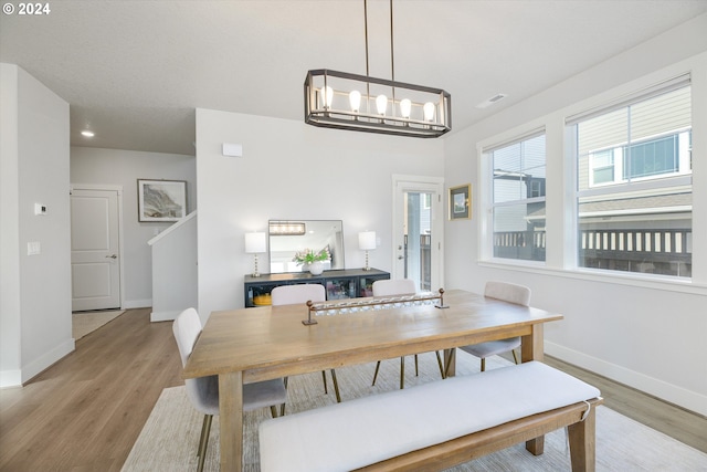 dining space with an inviting chandelier and light hardwood / wood-style floors