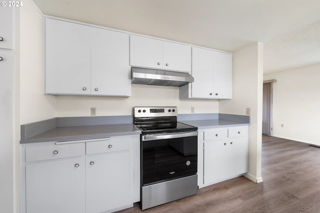 kitchen featuring a textured ceiling, white cabinetry, hardwood / wood-style floors, and electric range