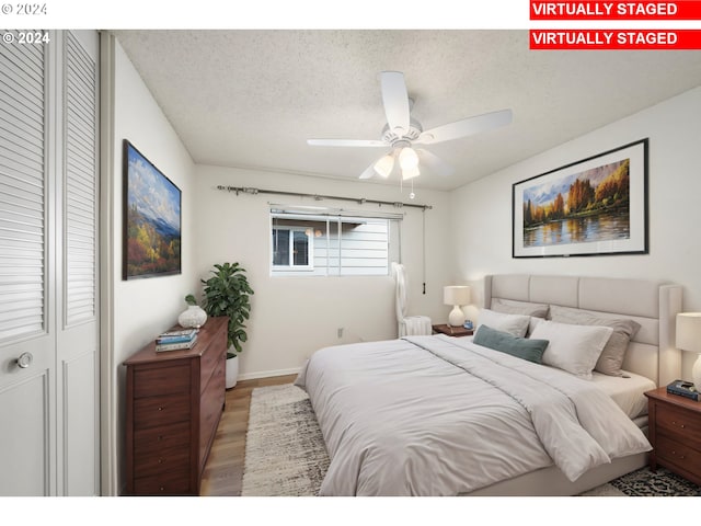 bedroom featuring ceiling fan, a textured ceiling, a closet, and light wood-type flooring