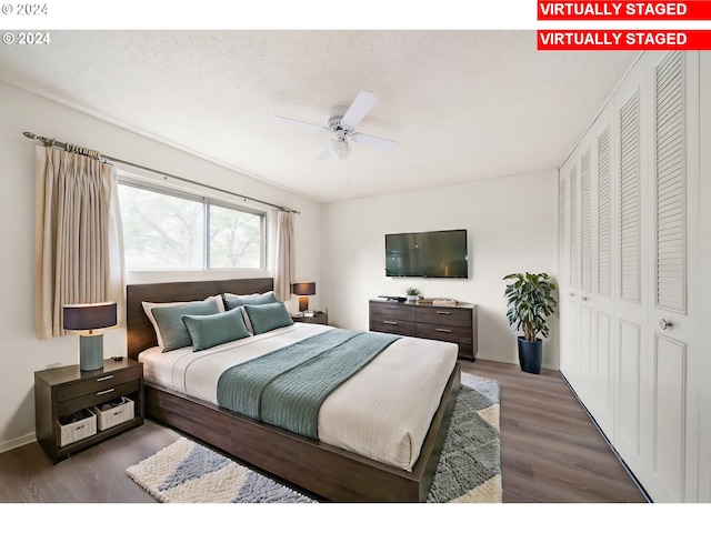 bedroom with a textured ceiling, dark hardwood / wood-style floors, ceiling fan, and a closet