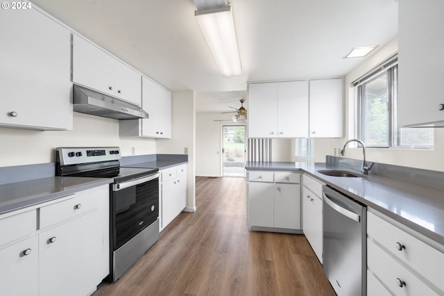 kitchen with stainless steel appliances, sink, hardwood / wood-style flooring, a healthy amount of sunlight, and white cabinets