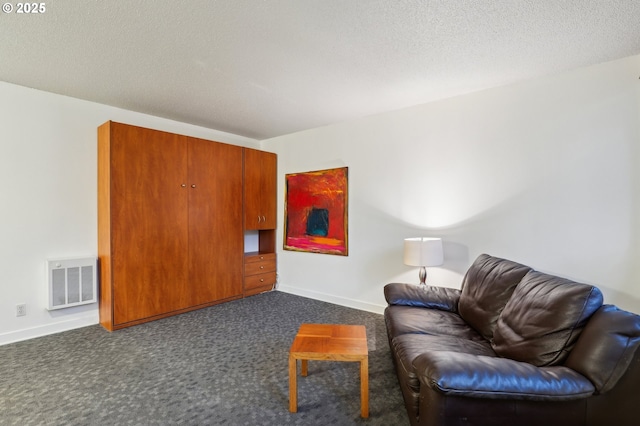 living area featuring dark carpet and a textured ceiling