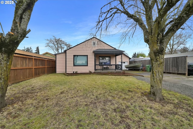 rear view of house featuring fence and a yard