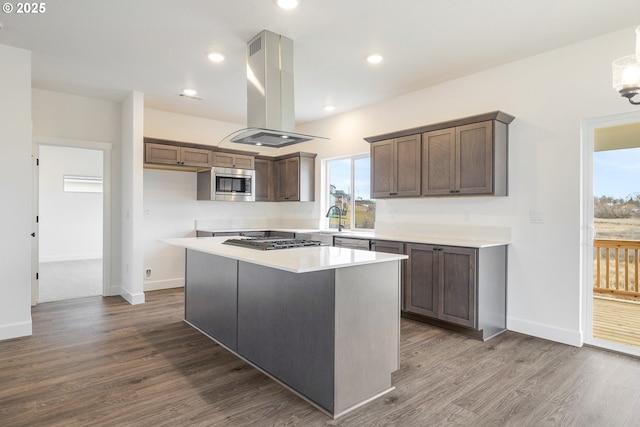 kitchen with sink, island range hood, a center island, dark hardwood / wood-style floors, and stainless steel appliances