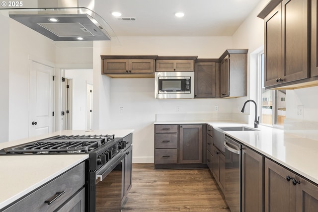 kitchen with dark brown cabinetry, appliances with stainless steel finishes, dark hardwood / wood-style floors, and sink