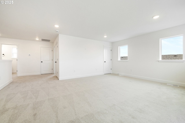 spare room with plenty of natural light and light carpet