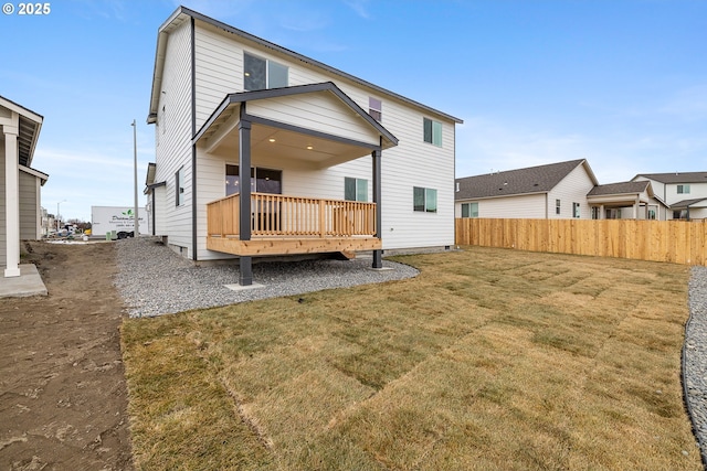 back of property with a wooden deck and a yard