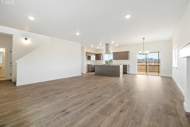 unfurnished living room with dark hardwood / wood-style flooring, a notable chandelier, and sink