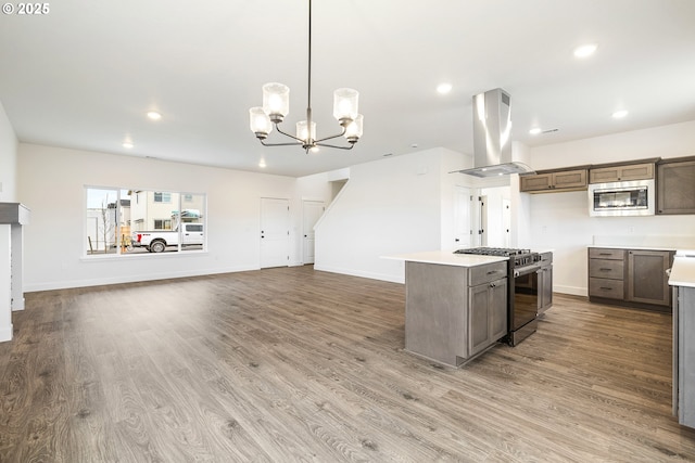 kitchen featuring decorative light fixtures, stainless steel appliances, hardwood / wood-style flooring, and island exhaust hood