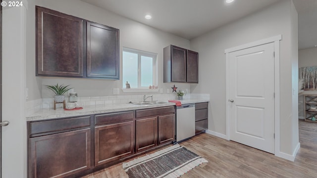 kitchen with baseboards, dark brown cabinets, light wood-type flooring, stainless steel dishwasher, and a sink