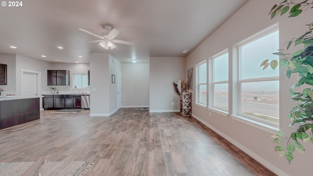 unfurnished living room with recessed lighting, ceiling fan, light wood-style flooring, and baseboards