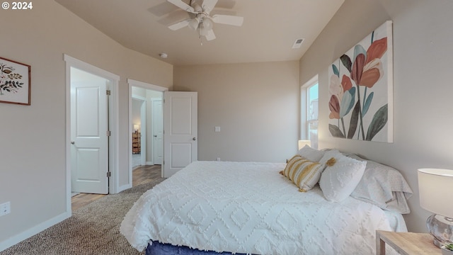 carpeted bedroom featuring visible vents, baseboards, and a ceiling fan