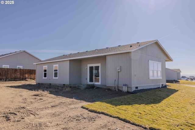 back of property featuring crawl space, a lawn, and fence