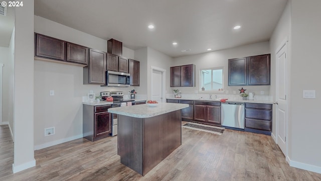 kitchen with light countertops, appliances with stainless steel finishes, dark brown cabinets, and light wood-style floors