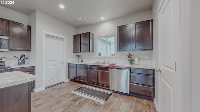 kitchen with dark brown cabinets, appliances with stainless steel finishes, a sink, and visible vents