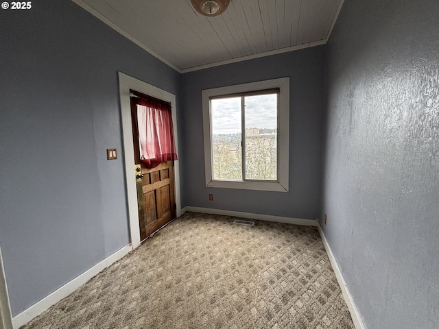 empty room featuring carpet flooring, wooden ceiling, and ornamental molding