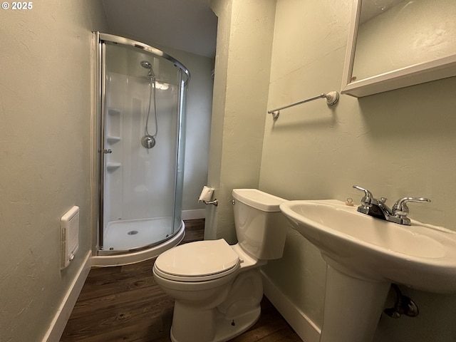 bathroom featuring hardwood / wood-style floors, toilet, and a shower with shower door