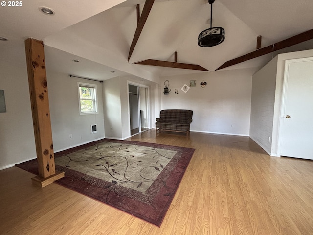 unfurnished living room with hardwood / wood-style floors and lofted ceiling with beams