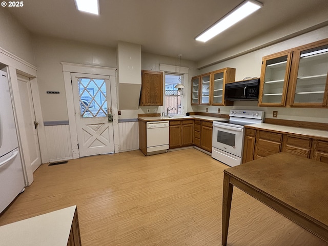 kitchen featuring sink, hanging light fixtures, white appliances, and light wood-type flooring