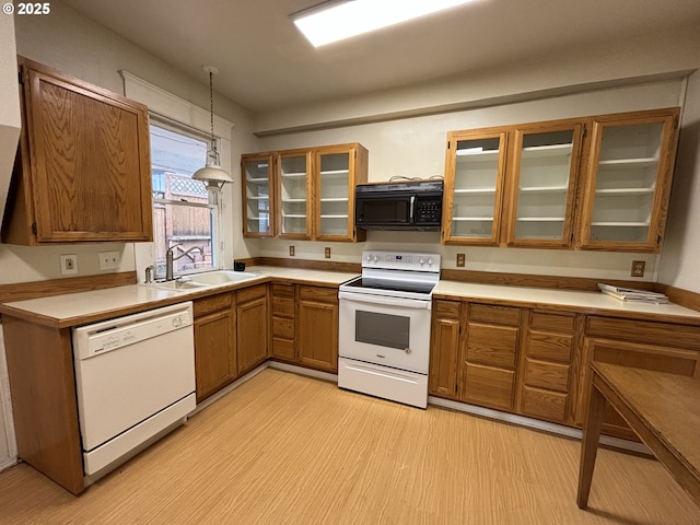 kitchen featuring white appliances, sink, and hanging light fixtures