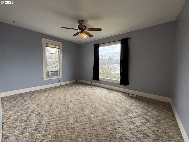 empty room with cooling unit, ceiling fan, carpet floors, and a healthy amount of sunlight