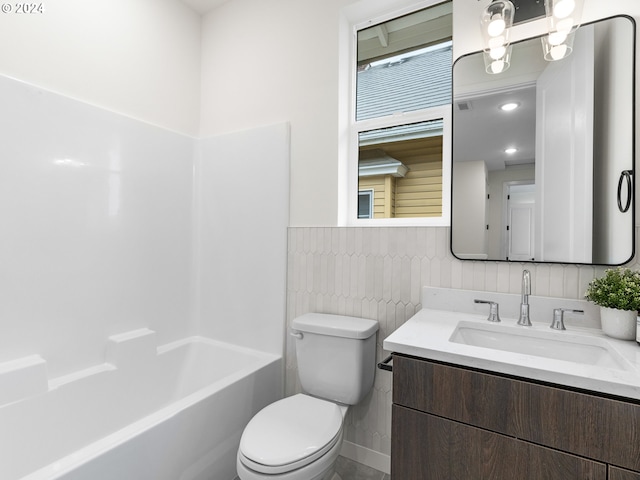 full bathroom with vanity, toilet, shower / tub combination, and tile walls