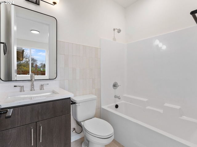 full bathroom with vanity, bathtub / shower combination, tile walls, and toilet